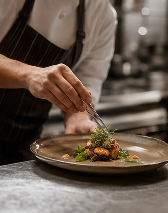 Chef plating a fire-led main course